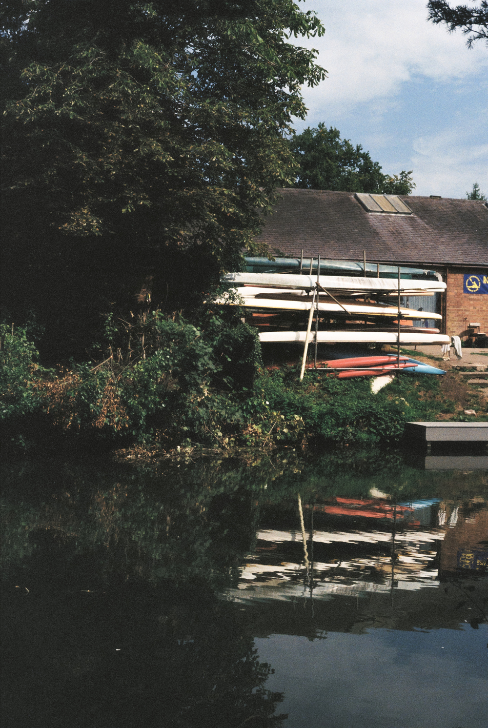 Canoes and their reflection on the Leam river.