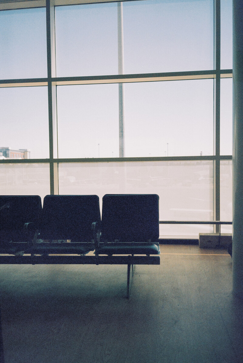 Empty seats beside large windows.