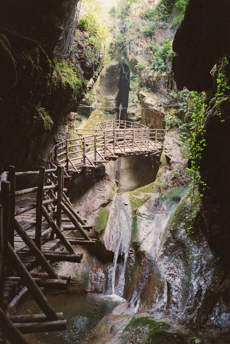 Water flowing through a rocky gorge beside a wooden walkway.